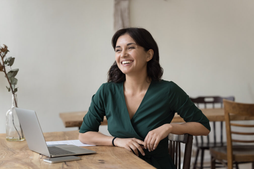 Entrepreneuse devant son ordinateur souriant